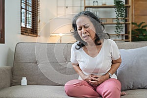 Elderly asian woman having painful from stomach ache at home,Senior female suffering with abdominal pain