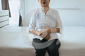 Elderly asian woman having painful stomachache on bedroom,Female suffering from abdominal pain while lying at house