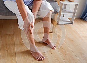 Elderly asian woman holding a leg that is painful from varicose veins or from osteoarthritis, Various illnesses of the elderly and