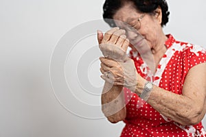 Elderly Asian woman patients suffer from numbing pain in hands from rheumatoid arthritis. Senior woman massage her hand with wrist