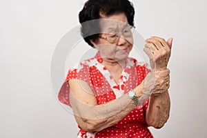 Elderly Asian woman patients suffer from numbing pain in hands from rheumatoid arthritis. Senior woman massage her hand with wrist