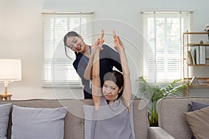 elderly Asian woman physical therapy with support of nurse or caregiver. Elderly woman doing exercises for patient with