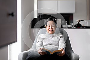 Elderly asian woman reading a book at home,Relax time,Senior lifestyle concept,Long sighted
