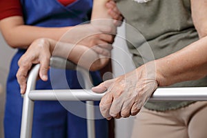 Elderly asian woman using a walker at home with daughter take ca