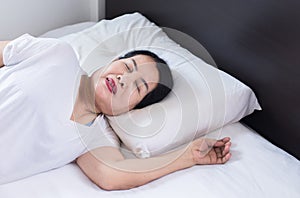 Elderly asian women sleeping on the bed and grinding teeth,Female tiredness and stress photo