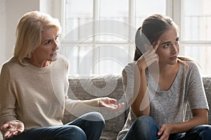 Elderly authoritative mom lecturing annoyed adult daughter