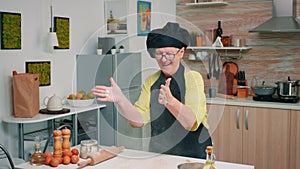 Elderly baker enjoying cooking with flour