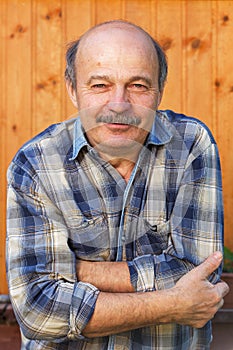 Elderly bald man with a mustache froze. Dressed not for the weather