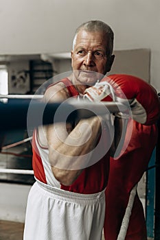 Elderly boxer thinks about tactics before a fight in the ring