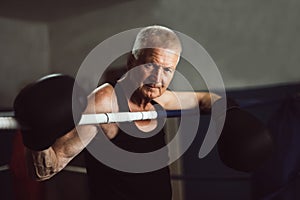 Elderly boxer thinks about tactics before a fight in the ring