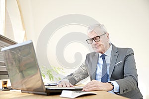 Elderly businessman working laptop