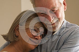 Elderly care mature couple hugging and dreaming together at home. One senior man and woman bonding each other smiling. Happy love
