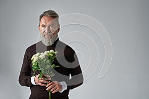 Elderly caucasian man with bouquet of white roses