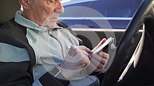 Elderly caucasian man sitting in car and using phone. active modern pension people