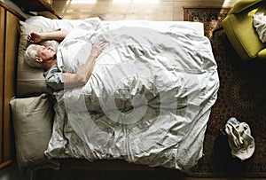Elderly Caucasian man sleeping on the bed photo