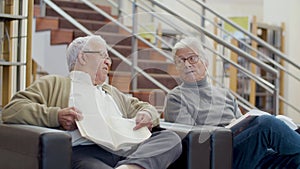 Elderly Caucasian men sitting in library and talking