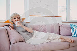 Elderly caucasian old aged woman enjoying afternoon tea at home.