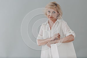 Elderly caucasian old aged woman portrait gray haired portrait with shopping bags.