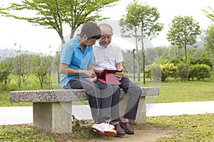 Elderly Chinese couple looking at the mobile tablet