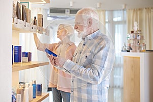 Elderly couple choosing cosmetics in a beauty shop