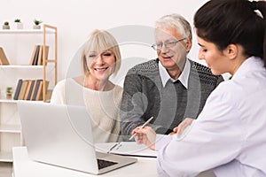 Elderly couple discussing treatment plan with doctor