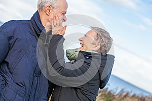 Elderly couple embracing and celebrating the sun