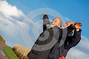 Elderly couple embracing and celebrating the sun