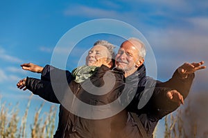 Elderly couple embracing and celebrating the sun