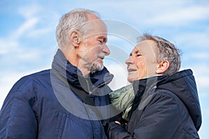 Elderly couple embracing and celebrating the sun