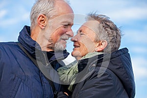 Elderly couple embracing and celebrating the sun