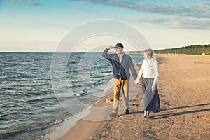 elderly couple having romantic walk on the beach