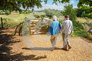 Elderly couple hold hands,walking in the British countryside