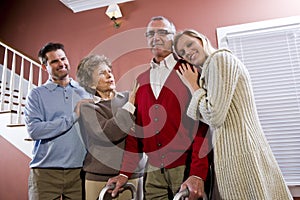 Elderly couple at home with adult children