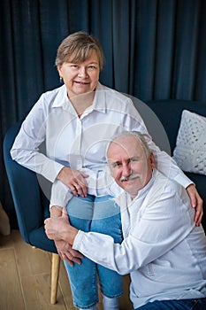 Elderly couple is hugging on a sofa blue and white colours photo