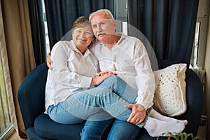 Elderly couple is hugging on a sofa blue and white colours photo