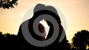 Elderly couple kissing at sunset, romantic moment, love feeling, happiness