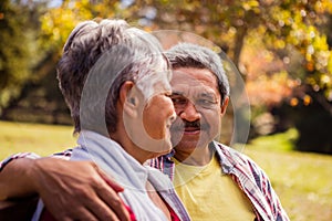 Elderly couple looking at each other while sitting on a bench