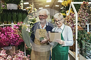 Senior couple in own flower shop. Concept of small business