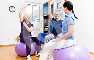 Elderly couple at physiotherapy on gymnastic balls