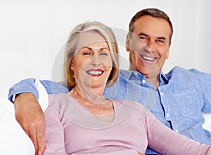 Elderly, couple and portrait or happy on sofa with support, relationship and marriage in retirement home. Senior, man
