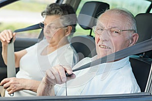 Elderly couple putting seat belt