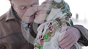 Elderly couple relaxing in winter time in the park. Happy grandfather and grandmother walking together