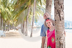 Elderly couple at resort , near the palm. Older man and woman