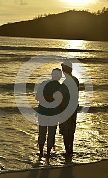 Elderly couple rest at tropical beach at sunset