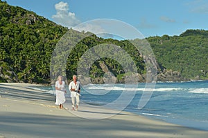 Elderly couple running on beach