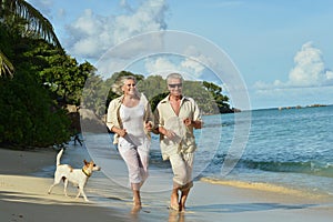 Elderly couple running on beach