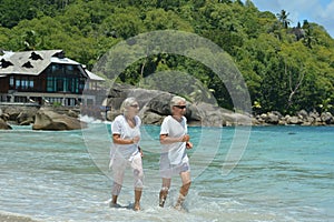 Elderly couple running  on beach