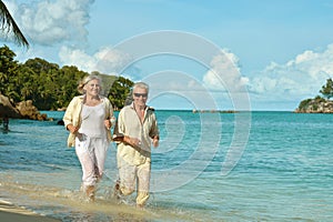 Elderly couple running on beach