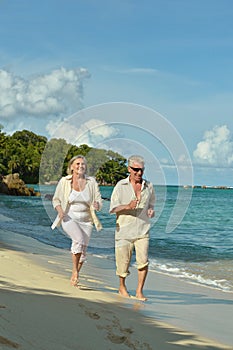 Elderly couple running on beach