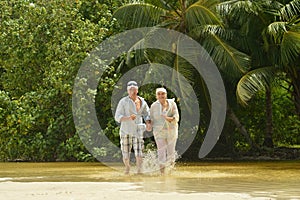 Elderly couple running on beach